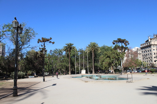 Barcelona, Spain - June 13, 2022:  People walk along the wide palm tree lined Promenade of Passeig de Lluís Companys towards the Ciutadella Park in Barcelona Spain