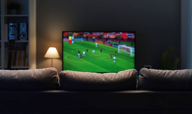 match de football sur écran large tv - man made structure high definition television domestic room living room photos et images de collection