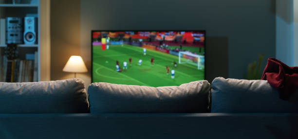match de football sur écran large tv - man made structure high definition television domestic room living room photos et images de collection