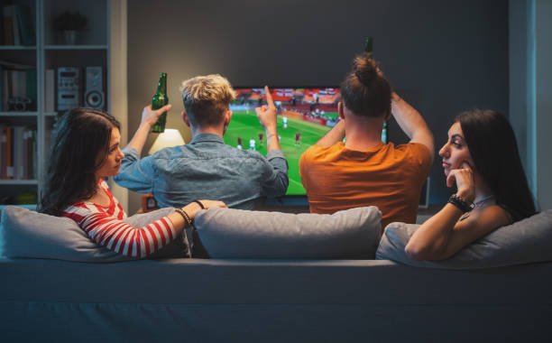 istock Girls talking while men are watching soccer on TV 1412870710
