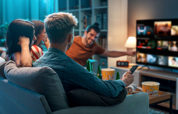 Friends watching movies together at home stock photo