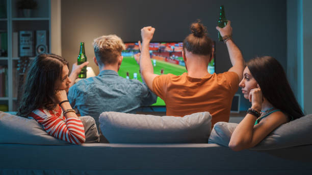 istock Girls talking while men are watching soccer on TV 1412870934
