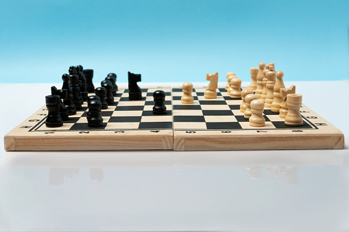 Front view of wooden chess board and chees pieces set to play. Mirror image of the game