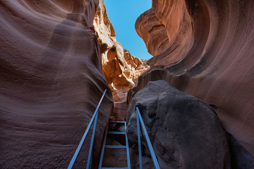View along a hike inside the deep and narrow Antelope Canyon. This slot canyon is located near the city of Page in Arizona, USA. The walls are shaped like waves.