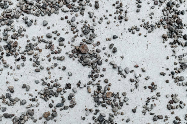 istock close-up of small gray stones scattered on light stone surface. Abstract background texture 1412874259