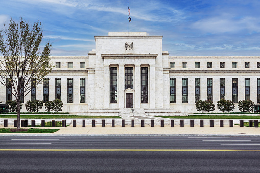 Treasury Department Building on Constitution Avenue, Washington DC, USA. Blue Sky with Puffy clouds, Street, Sidewalk and Trees are in the image. Canon EF 24-105mm/4L IS USM Lens.\n.