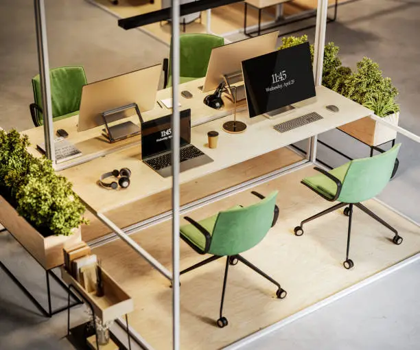 High angle view of coworking space with laptop, computers and plants on desk. 3d render of modern office work space.