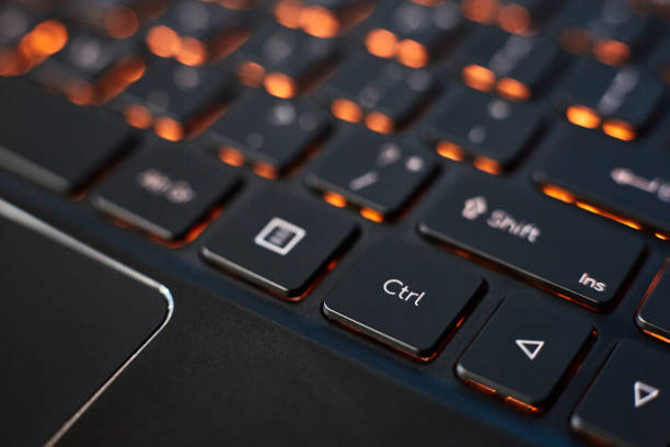 istock Close-up of a laptop keyboard with orange backlight. 1412875347