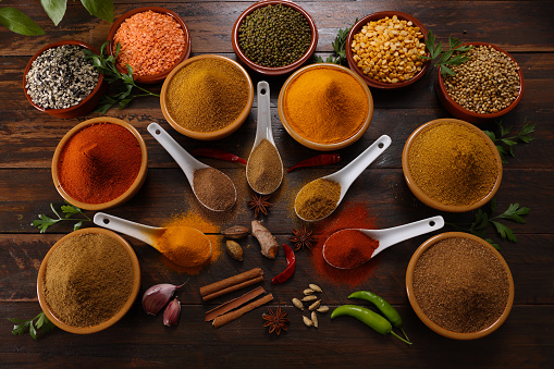 Cooking background, home cooking concept. Spoon, herbs and spices on wooden background, top view,
