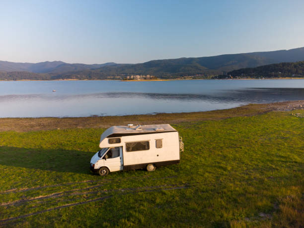 istock Aerial view of a camper van parked on a beach, mountain range landscape 1412877184
