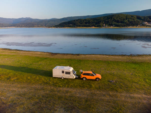 istock Aerial view of a camper van parked on a beach, mountain range landscape 1412877189