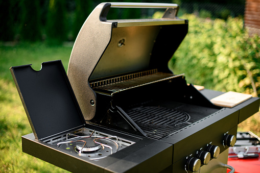 selective focus on grate of modern stainless portable BBQ barbecue grill at yard. Outdoor major kitchen appliances