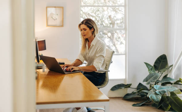 istock Female entrepreneur typing on a laptop in her office 1412879536
