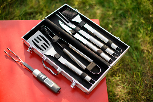 Top view on set of BBQ tools. Barbecue steel instruments kit - tongs, spatula, fork. Close-up.