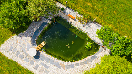 Relaxation zone with fish farming in an organic garden from above. Sustainable development in gardening and aquaculture.