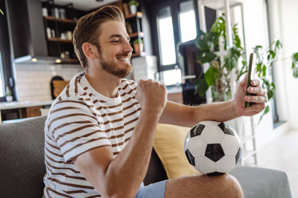 istock Young man checking soccer game results online 1412880379