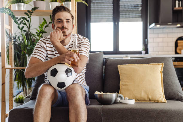 istock Nervous young man watching a soccer game 1412880837