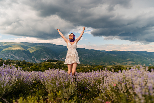 Beautiful young woman in lavender field. Enjoying the nature.