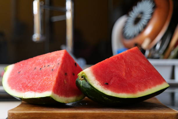 istock Two watermelon pieces on a wooden cutting board 1412882306