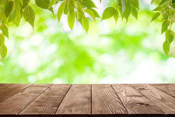 istock Empty wooden table with lush foliage background 1412882692
