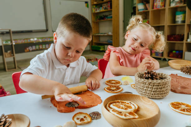 kinder machen abdrücke auf dem teig mit natürlichen materialien - kunst und handwerkserzeugnis stock-fotos und bilder