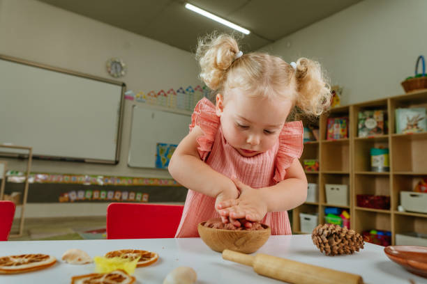 istock Preschool girl making prints on the dough using natural materials 1412887940