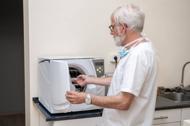 medico che mette gli strumenti in autoclave per la lavorazione. attrezzatura di laboratorio. strumenti di sterilizzazione, purificazione batterica e disinfezione in clinica dentale. - machine teeth immagine foto e immagini stock