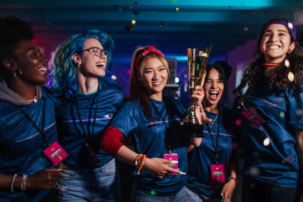 A multiracial group of female professional gamers celebrates a win in a tournament