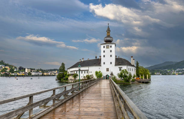 Gmunden, Austria, July 7, 2022: View of the castle Ort in the Traunsee Lake in Upper Austria. At present the castle is being used for a study center of the Austrian Ministry for Land and Forestry. In 1996, it began to be used as a location for the TV series Schlosshotel Orth.
