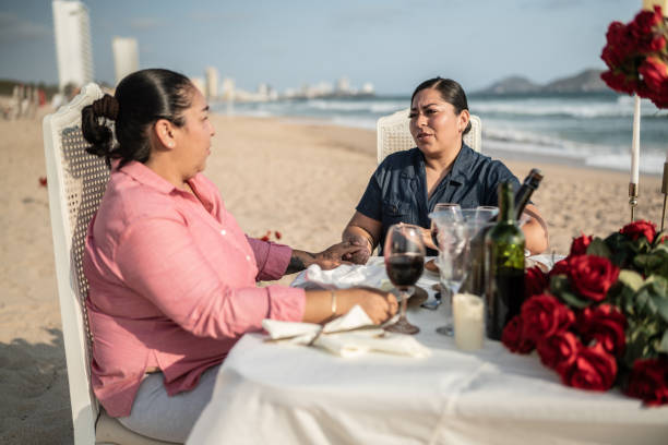 istock Gay couple on a romantic dinner at the beach 1412892032