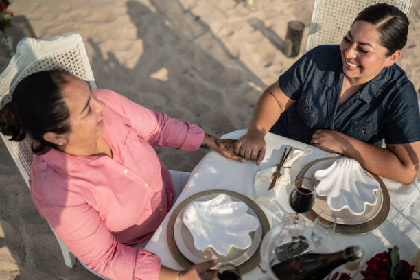 istock Gay couple on a romantic dinner at the beach 1412892035
