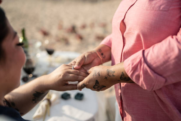 Woman making a marriage proposal to her girlfriend on the beach