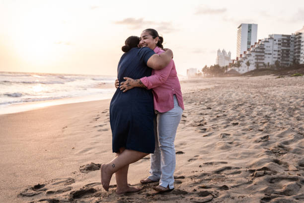 istock Lesbian couple embracing on the beach 1412892268
