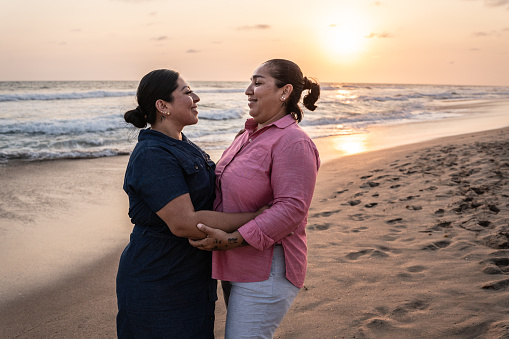 Lesbian couple embracing on the beach