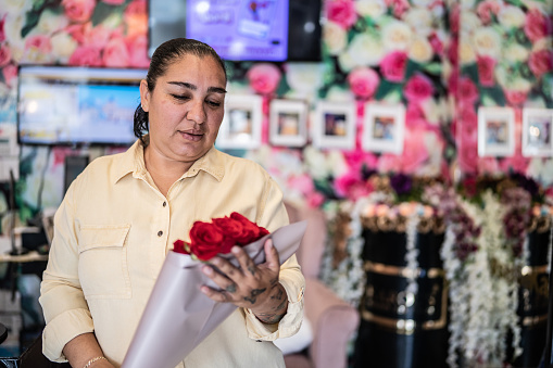 Woman buying a flower bouquet at store