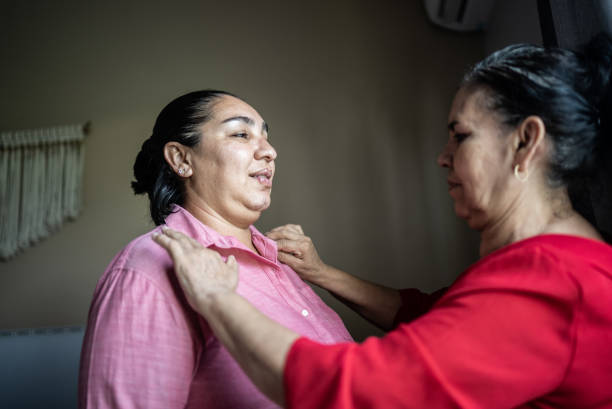 Mother helping daughter getting dressed at home