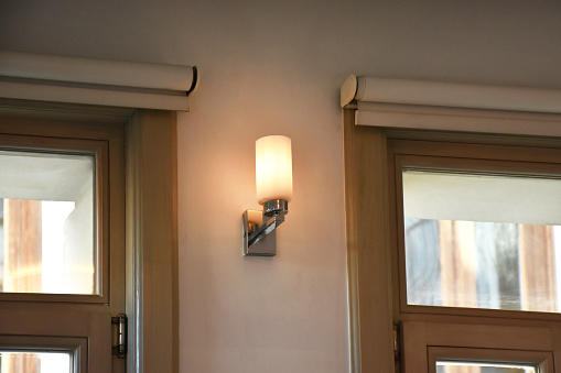 Sconce lamp hanging on the wall with windows