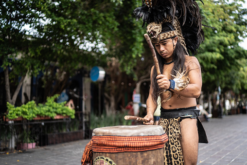 Aztec performer playing the drum outdoors