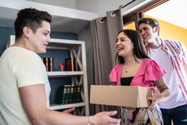 istock Young man receiving gift from friends at home 1412896736