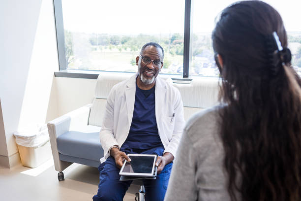 istock Cheerful ER doctor talks to unrecognizable female patient 1412897700