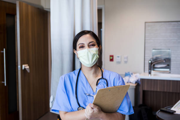 istock Female ER nurse with protective mask looks at camera 1412897706