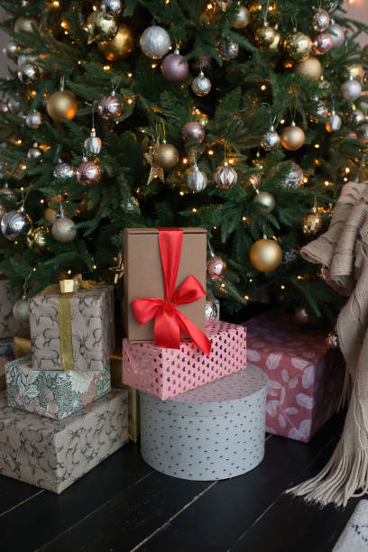 istock A box with a red ribbon, a gift lies under the Christmas tree 1412899401