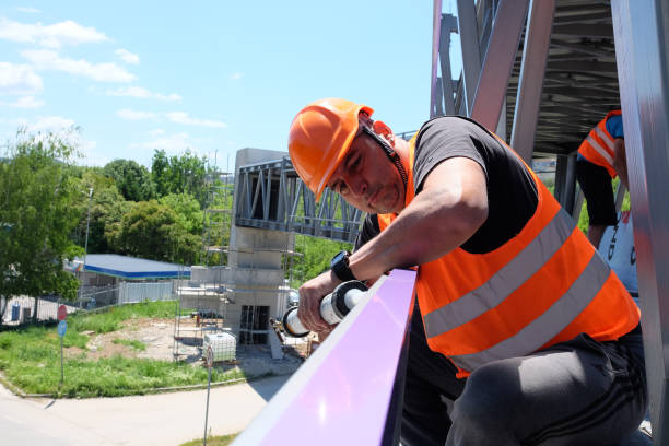 istock A worker puts glue for mounting exterior aluminum composite panels 1412899782