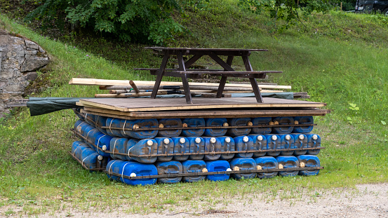A raft made of plastic cans. Rafting down river Gauja in Latvia with the barbecue ready to roast on the back of the raft