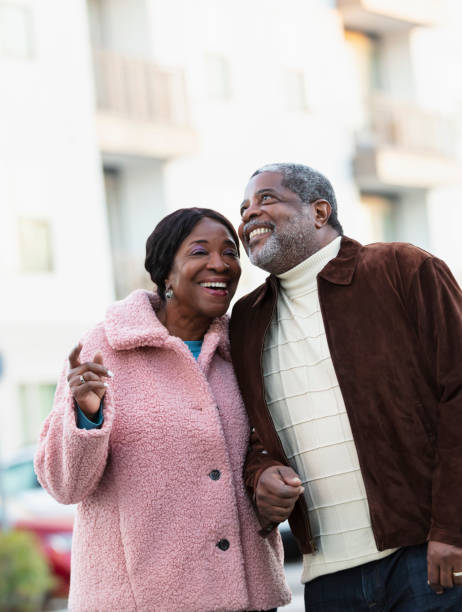 пожилая афроамериканская пара на свежем воздухе, улыбается - men african descent looking up smart casual стоковые фото и изображения