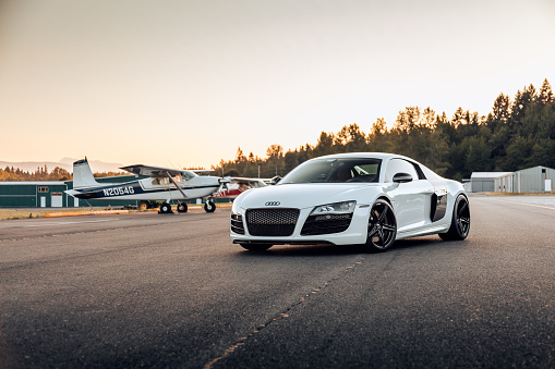 Renton, WA, USA\n4/15/2022\nWhite Audi R8 parked with small planes in the background