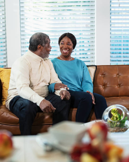 istock Senior African-American couple sitting on couch talking 1412904475