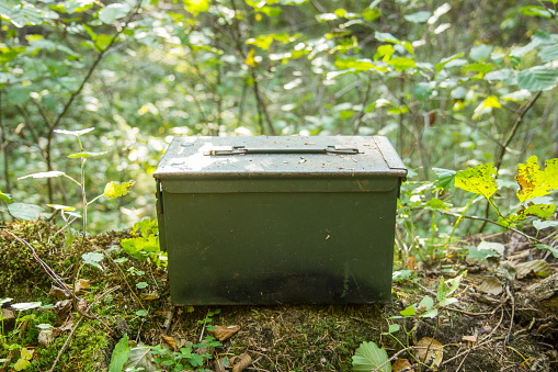 big metal box used as geocaching container in the woods