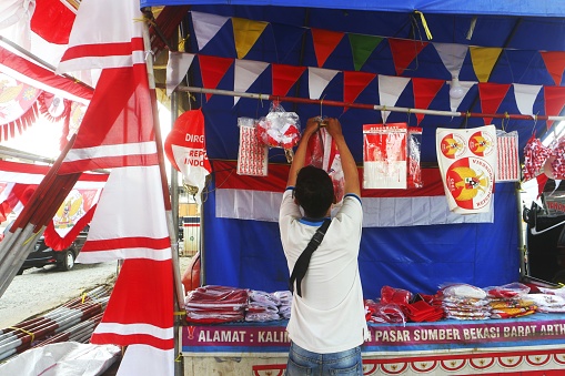 Bekasi, Indonesia - July 30, 2022: The flag seller sells various kinds of red and white flags. To be bought by people who will celebrate Indonesia's independence day, which is celebrated on August 17th. This flag seller is only present during the month of August.