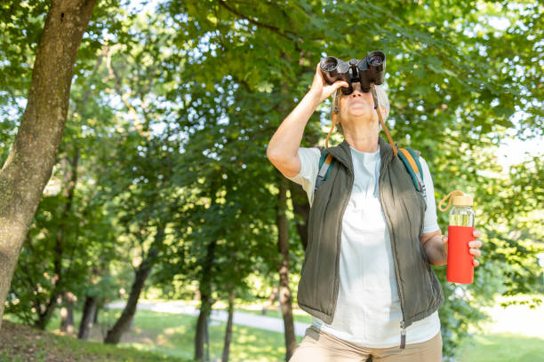 istock Senior woman using binoculars on a hike 1412910709